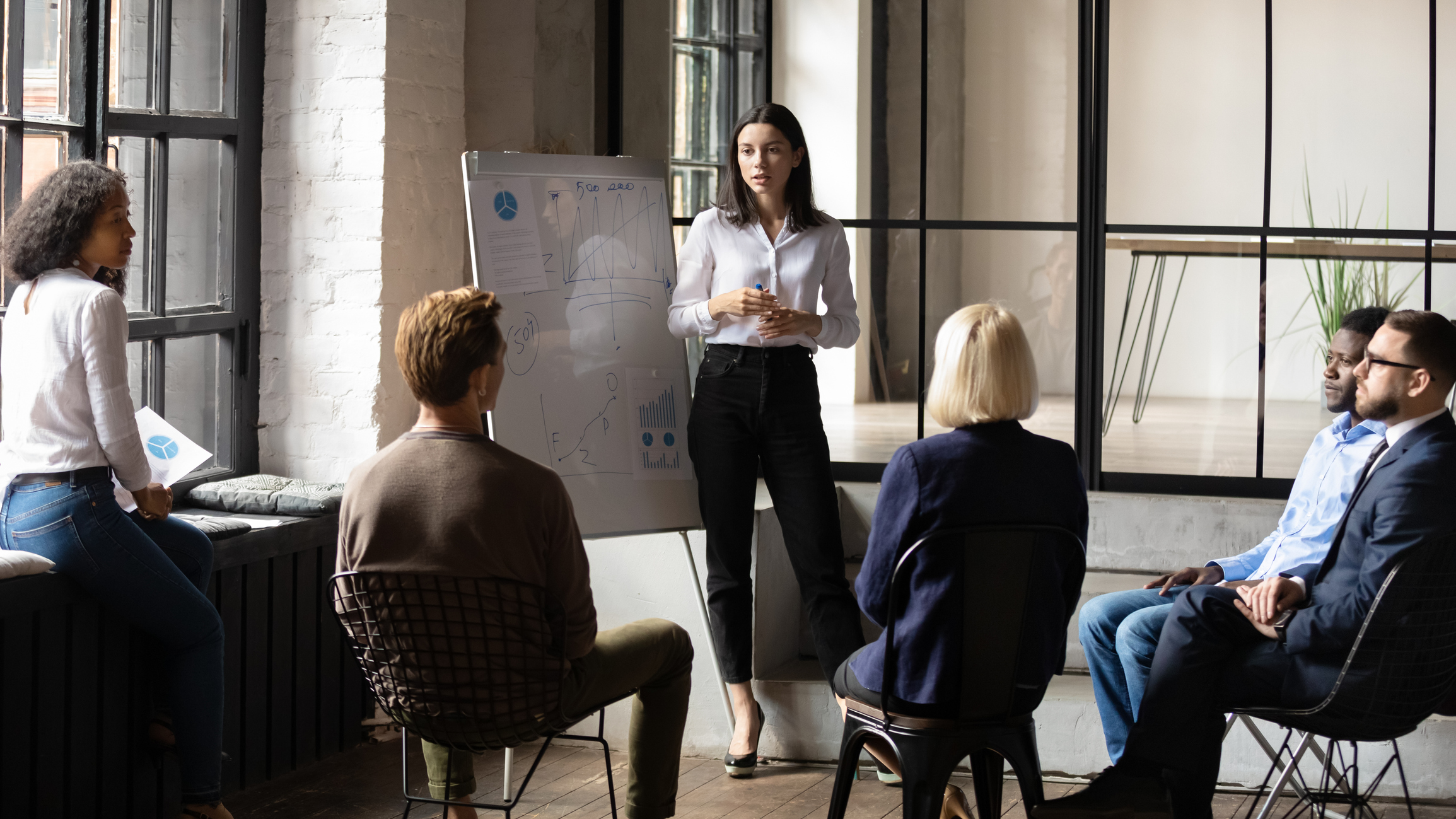 woman with whiteboard lecturing infront of group